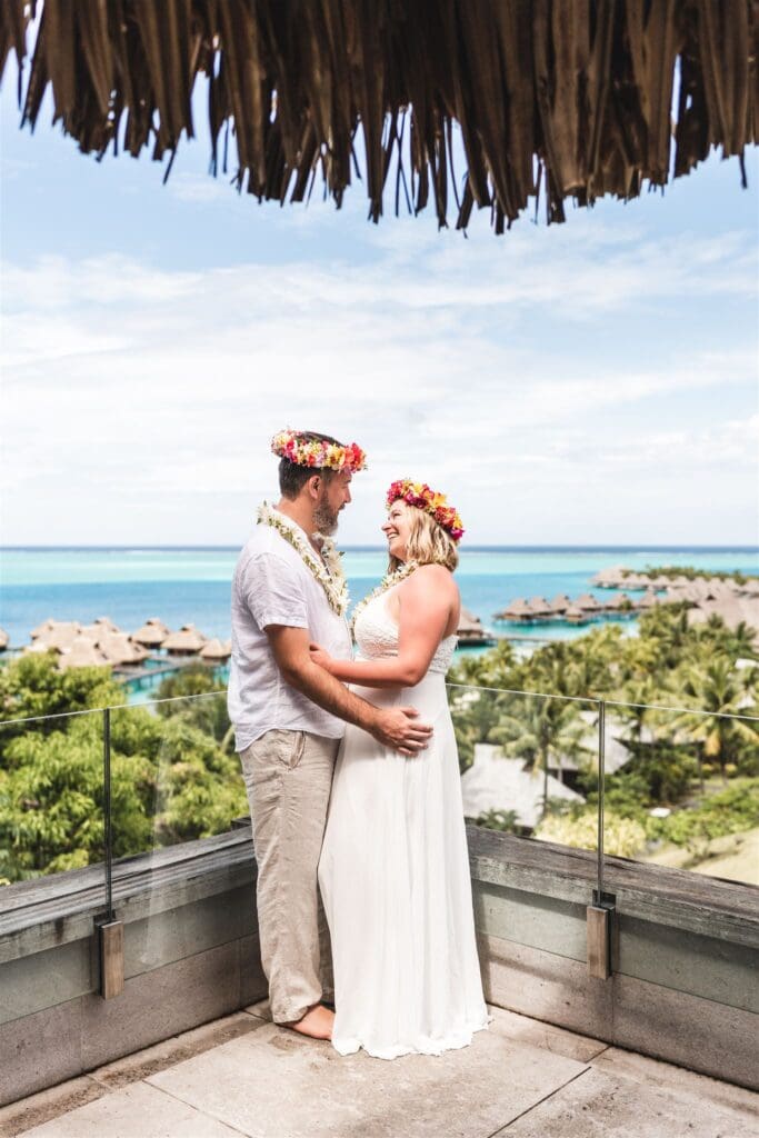 Vow renewal photo of Blair and Brady standing on a balcony overlooking the resort.