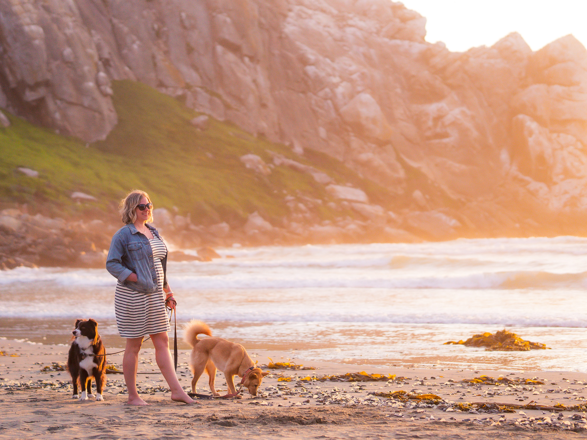 Blair stands on the beach at Morro Bay in San Luis Obispo, California with her two dogs: June, a yellow mutt, and Margot, a red and white Australian Shepherd.